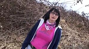 Une adolescente amateur aux seins et aux lunettes dressés fait une fellation en plein air
