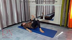 Model gimnastik dalam stoking dan seluar yoga memamerkan fleksibiliti beliau