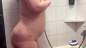 Gros seins et gros cul en exposition dans une douche taquine
